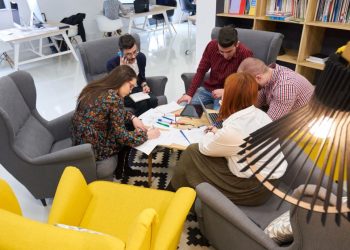 A team of entrepreneurs sitting around a table in a startup accelerator working on their project