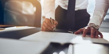 Investor signing an angel investment contract, closing a deal with an entrepreneur to buy shares in his company