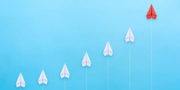 A series of paper lines flying above a blue ocean, with one in bright red symbolising the best exit strategy