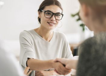 A new employee being recruited by an in-house HR team and shaking hands to signify acceptance of employment