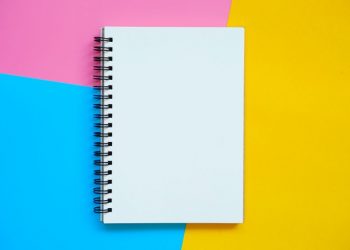 A blank notebook sitting on the bright coloured background, a place where you can write a new business name