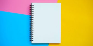 A blank notebook sitting on the bright coloured background, a place where you can write a new business name