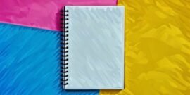 A blank notebook sitting on the bright coloured background, a place where you can write a new business name