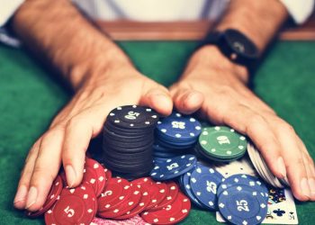 An man pushing all in his poker chips in during a game of Texas hold em poker, symbolsing that entrepreneurs can make the mistake of too much risk or overspending