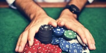 An man pushing all in his poker chips in during a game of Texas hold em poker, symbolsing that entrepreneurs can make the mistake of too much risk or overspending