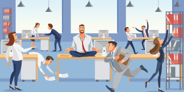 A man sitting on a desk meditating in the middle of a hectic workplace with colleagues running around frantically
