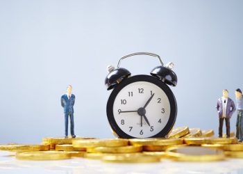 Clock sitting ontop of pile of money next to supplier and customer representing customer payment terms and times