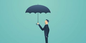 Insurance man in a black suit holding an umbrella symbolsing the protection business insurance can provide for small companies