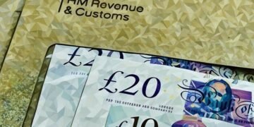 An envelope with British pounds in it being sent to the HMRC to pay a corporation tax bill