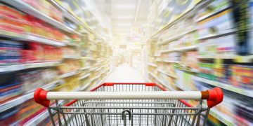 A supermarket trolley rushing through a supermarket showing all the products that have been sold into the supermarket