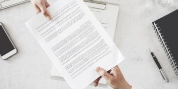 An entrepreneur handing voer company formation paperwork to his lawyer to file with companies house