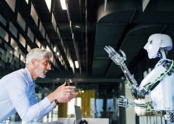 A colleauge teaching a robot colleague how to be more productive