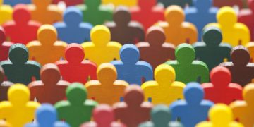 A series of coloured wooden people outlines , made up of many different colours symbolising different cultures