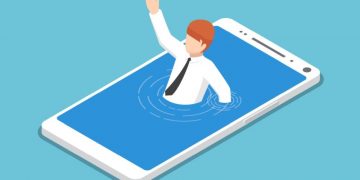 An entrepreneur drowning in a smartphone, as an example of how overwhelming a social media crisis can be