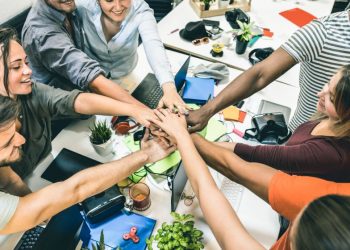A group of start-up interns fist bumping at a silicon valley start-up