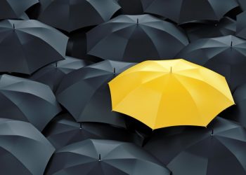 A bright yellow umbrella in a sea of black showing how a unique product and selling proposition stands out