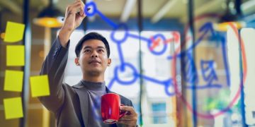 Chinese entrepreneur writing on a whiteboard in an accelerator