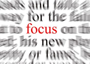 The word "focus" in red in the middle of blurred text, demonstrating how focus can bring clarity