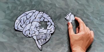 A brain shown in puzzle format, with a person removing a puzzle piece of the brain