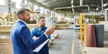 Business owner and financier discussing which assets can be financed in his warehouse to avoid liquidation