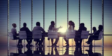 Team around conference table at office building discussing corporate venture deal