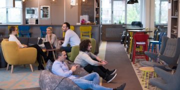 Two colleagues playing computer games at work as an example of how playing at work can be productive