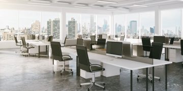 The interior of a sophisticated office space in a London skyscraper but white desk and black chairs
