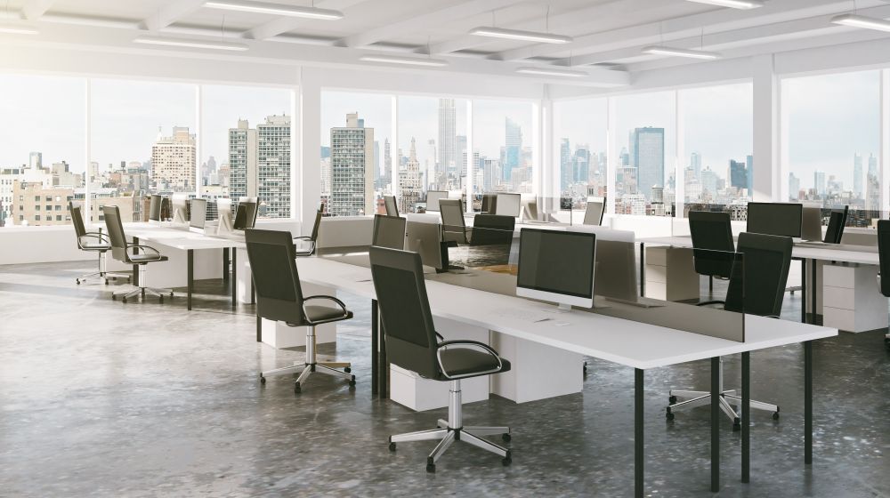 The interior of a sophisticated office space in a London skyscraper but white desk and black chairs