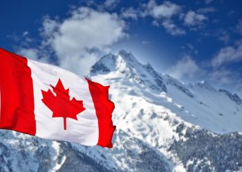 Canadian flag flying over a mountain, symbolising Canada