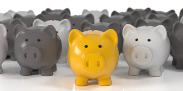 A series of piggy banks in grey with one highlighted in gold exampling the best business bank and account found