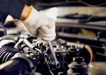 Closeup of the hands of a mechanic fixing a car by the roadside