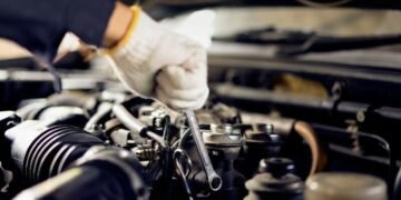 Closeup of the hands of a mechanic fixing a car by the roadside