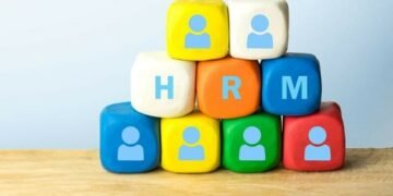Human Resources Management in between dice with pictures of tiny office workers on them