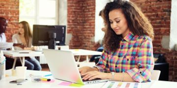 A blogger writing at her laptop after receiving a great outreach email