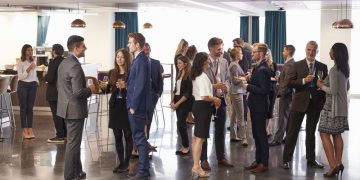 A group of business people at a networking event trying out different networking techniques
