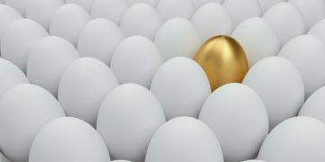 Golden egg in white eggs representing a valuable business