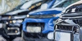 Closeup of landrover defender and other cars in a showroom