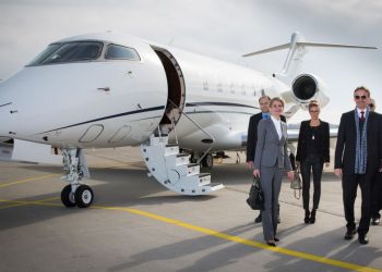 Famous entrepreneur and his team step out of their business jet that has just landed