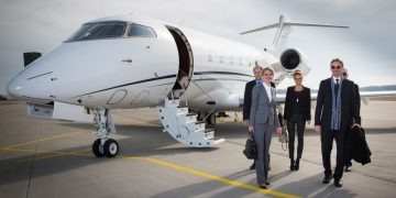 Famous entrepreneur and his team step out of their business jet that has just landed