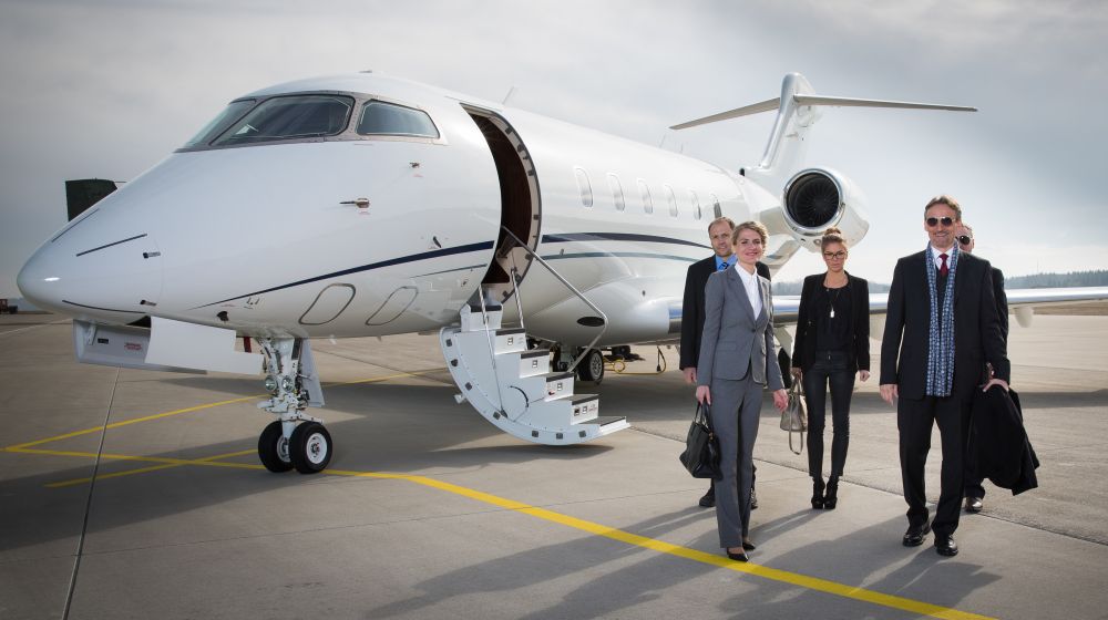 Famous entrepreneur and his team step out of their business jet that has just landed