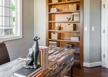 A perfectly set home office with a desk, office chair and dog statue