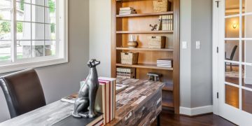 A perfectly set home office with a desk, office chair and dog statue