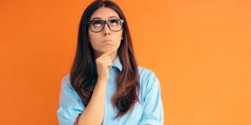 A women with glasses making a decision about whether to remain an employee or become an entrepreneur