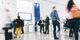 A B2B tradeshow with business people walking around viewing kiosks because the event was well marketed