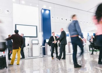 A B2B tradeshow with business people walking around viewing kiosks because the event was well marketed