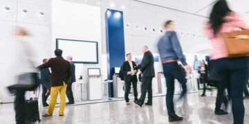 A B2B tradeshow with business people walking around viewing kiosks because the event was well marketed
