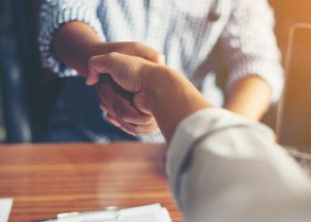 A salesman shaking a customers hand and closing a sales deal in the process