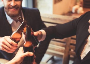 Several colleagues drinking at a bar after work, representing a negative or positive drinking culture around work