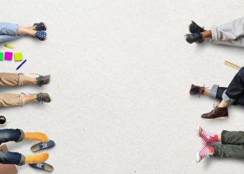 Employees lying down on the floor in a relaxed way with work material around them symbolising a poor work ethic
