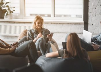 A team of colleauges sitting on bean bags working exampling how employees can be productive with more flexibility in the workplace